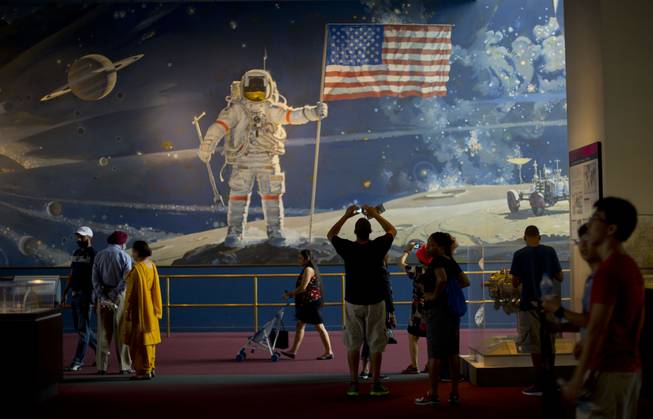 Visitors to the Smithsonian's National Air and Space Museum walk past a depiction of space exploration by artist Robert T. McCall entitled 'The Space Mural: A Cosmic View', on the 45th anniversary of Apollo 11 lunar landing, in Washington, Sunday, July 20, 2014.