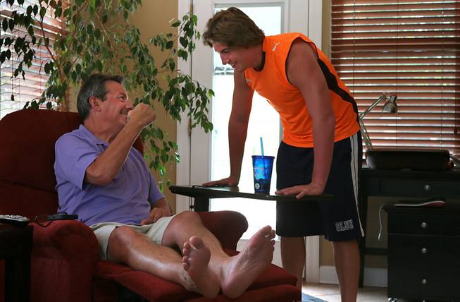 Dave Larson, who suffers from ALS, shows off his muscles to his son Arthur. Larson is undergoing the massage treatments to try to slow the atrophication of his muscles from the disease. The former Division 1 college soccer player had to give up going to the gym in January. His athletic build has long faded.
