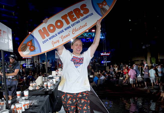 Defending champion Joey "Jaws" Chestnut celebrates after wining first place in the 2014 Hooters "World-Wide Wing Eating Championship" at the Hard Rock pool Tuesday, July 22, 2014. Chestnut ate 182 wings in 10 minutes.