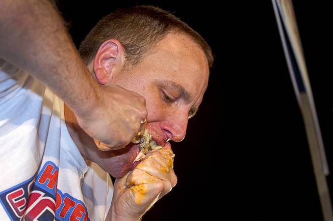 Professional eater Joey Chestnut competes during the 2014 Hooters "World-Wide Wing Eating Championship" at the Hard Rock pool Tuesday, July 22, 2014.