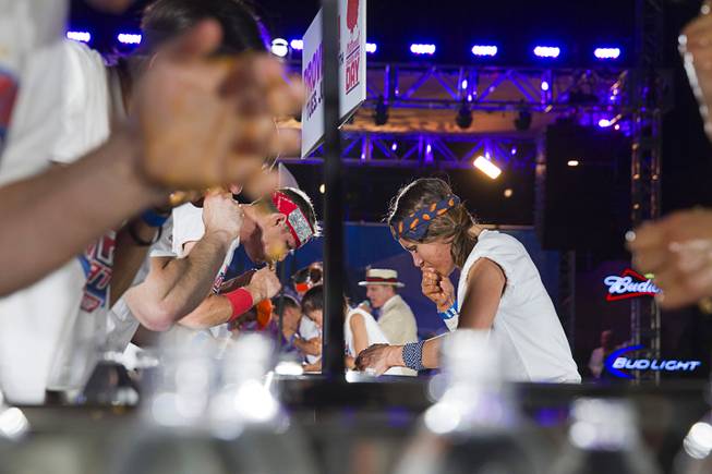 Competive eater Michelle Lesco, right, competes during the 2014 Hooters "World-Wide Wing Eating Championship" at the Hard Rock pool Tuesday, July 22, 2014.