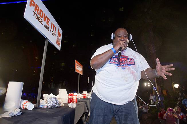 Professional eater Eric Booker entertains the crowd after competing in the 2014 Hooters "World-Wide Wing Eating Championship" at the Hard Rock pool Tuesday, July 22, 2014.