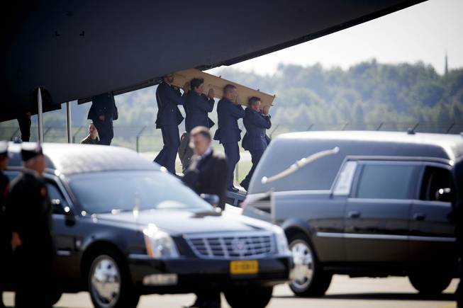 Pallbearers carry a coffin out of a military transport plane during a ceremony to mark the return of the first bodies, of passengers and crew killed in the downing of Malaysia Airlines Flight 17, from Ukraine at Eindhoven military air base, Netherlands, Wednesday, July 23, 2014. After being removed from the planes, the bodies were taken in a convoy of hearses to a military barracks in the central city of Hilversum, where forensic experts will begin the painstaking task of identifying the bodies and returning them to their loved ones. 