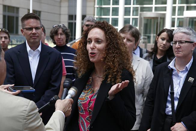 Attorney Mari Newman, center, talks with members of the media, as she stands with her plaintiffs and their supporters following a court hearing on sam sex marriage at the federal District Court, in Denver, Tuesday, July 22, 2014. 