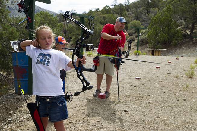 Justics Lavin, 8, lets an arrow fly at the Las Vegas Archers Spring Mountain Range near Mountain Springs Sunday, July 20, 2014. Jeremy Beard is at right.