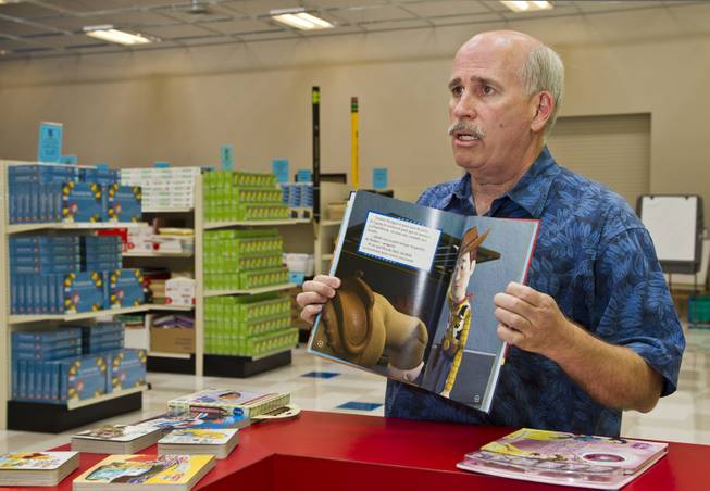 Tim McCubbin, director of the Public Education Foundation's Teacher EXCHANGE, displays one of the Spanish-language books available for teachers to purchase for cheap on Tuesday, July 22, 2014.  They are very popular items and thousands have been purchased for first and second language students.