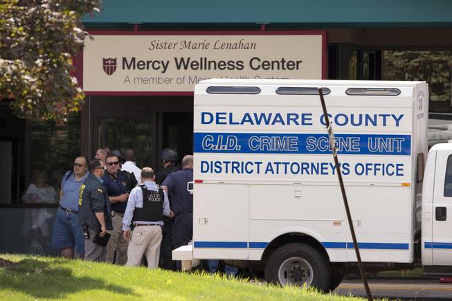 Investigators work the scene of a shooting Thursday, July 24, 2014, at Mercy Fitzgerald Hospital in Darby, Pa. A shooting at the suburban Philadelphia hospital campus has killed one worker and injured two other people. Prosecutor Jack Whelan says one of the injured is the gunman.