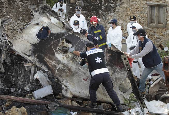 A forensic team recovers human remains among the wreckage of crashed TransAsia Airways flight GE222 on the outlying island of Penghu, Taiwan, Thursday, July 24, 2014. Stormy weather on the trailing edge of Typhoon Matmo was the likely cause of the plane crash that killed more than 40 people, the airline said Thursday.