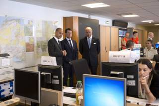 French Prime Minister Manuel Valls, center, speaks with French Foreign Affairs minister Laurent Fabius, right, and director of the French Foreign Affairs ministry's crisis center Didier Le Bret as they visit the French Foreign Affairs ministry's crisis center in Paris Friday, July 25, 2014, after a plane crashed in Mali. At least 116 people were killed in Thursday’s disaster, nearly half of whom were French. One of two black boxes was recovered from the wreckage in the Gossi region of Mali near the border with Burkina Faso, and was taken to the northern city of Gao, where a French contingent is based.