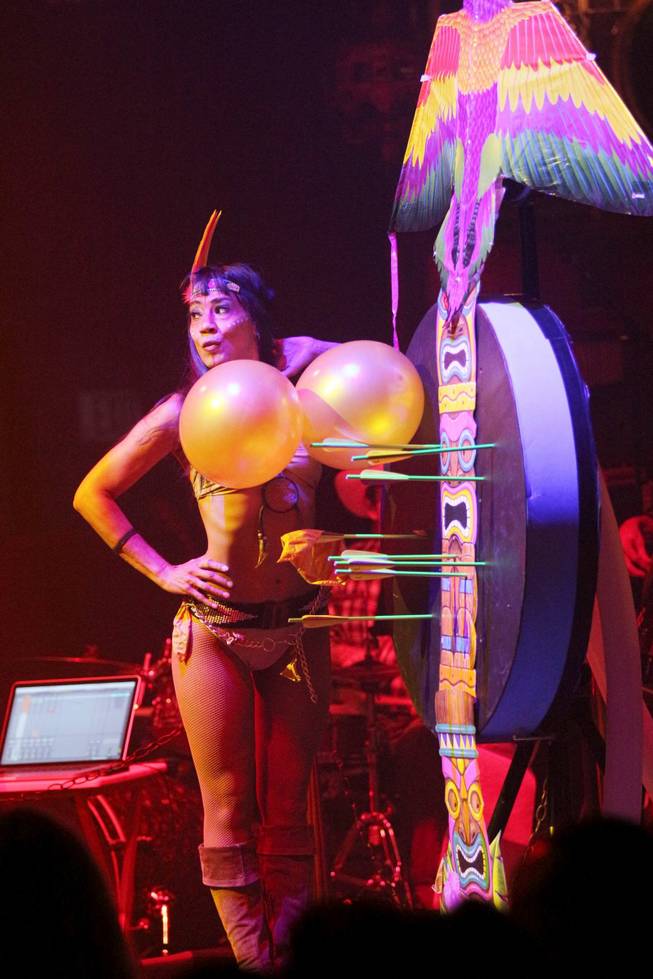 Naomi Gesmundo of the crossbow artist duo of Mr. and Mrs. G stand with a couple of targets for her husband, Ottavio, in Melody Sweets’ video-release party for the music video "Shoot 'em Up" at the "Absinthe" tent at Caesars Palace on Tuesday, July 22, 2014.