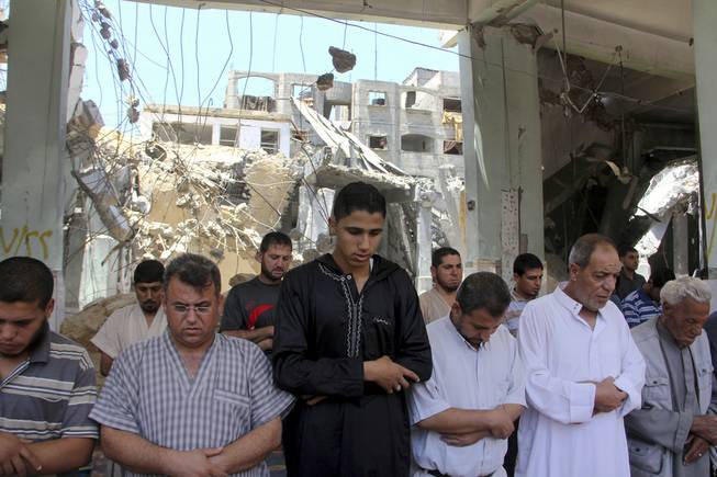 Palestinians pray the Friday prayer inside a destroyed Al Farouk mosque which was destroyed by an overnight Israeli strike on Tuesday, in Rafah in the southern Gaza Strip on Friday, July 25, 2014. 