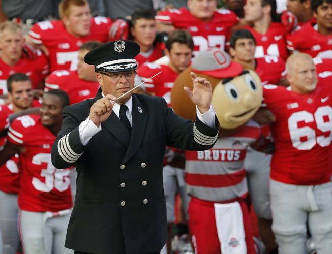 In this Sept. 7, 2013, photo, Ohio State University marching band director Jon Waters leads the band in "Carmen Ohio" following a NCAA football game against San Diego State at Ohio Stadium in Columbus, Ohio.