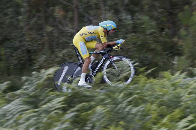Italy's Vincenzo Nibali, wearing the overall leader's yellow jersey, strains during the twentieth stage of the Tour de France cycling race, an individual time-trial over 33.6 miles with the start in Bergerac and finish in Perigueux, France, on Saturday, July 26, 2014.