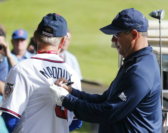 Former Atlanta Braves and Chicago Cubs pitcher Greg Maddux signs an autograph during a baseball Hall of Fame golf outing at Leatherstocking Golf Course on Saturday, July 26, 2014, in Cooperstown, N.Y. 