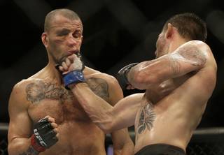 Tim Means, right, punches Hernani Perpetuo during the third round of a welterweight mixed martial arts bout at a UFC event in San Jose, Calif., Saturday, July 26, 2014. Means won by unanimous decision. (AP Photo/Jeff Chiu)