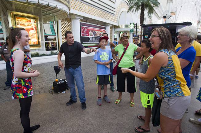 Tina Buchberger, right, of Marathon, Wisc. laughs as she assists magician Jesse Case with a trick at the Fremont Street Experience Sunday, July 27, 2014.