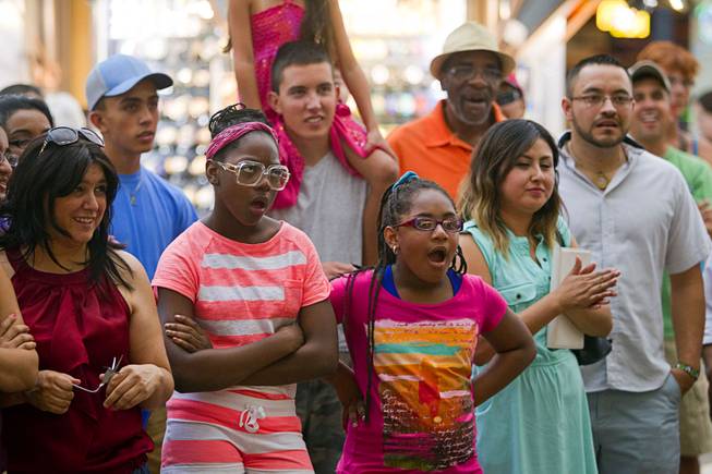 People watch a magician at the Fremont Street Experience Sunday, July 27, 2014.