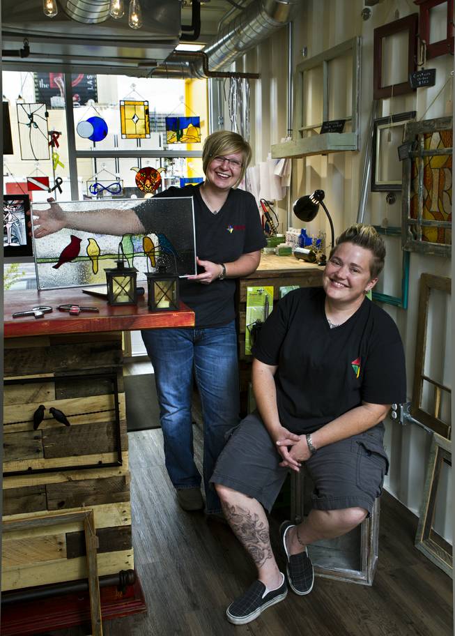 (From front) Owners Mya Daily and Ellisha Haddix of stained glass business Lead In the Window within their Container Park shop on Friday, July 25, 2014.
