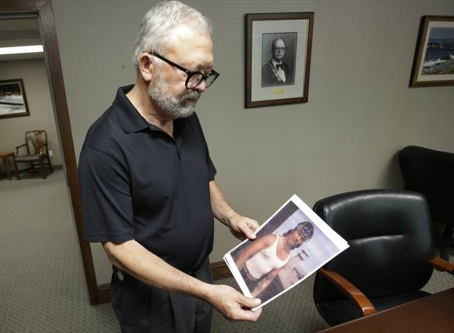 In this July 16, 2014, photo, Salt Lake City attorney Jesse Trentadue holds a photograph of his brother taken in the early 80s showing his dragon tattoo on his left forearm, which fit the description the FBI was circulating of "John Doe 2," during an interview in Salt Lake City. Trentadue's quest to explain his brother’s mysterious jail cell death has rekindled long-dormant questions about whether others were involved in the 1995 Oklahoma City bombing. Trentadue's Freedom of Information Act lawsuit against the federal government goes to trial Monday, July 28, 2014, in Salt Lake City.