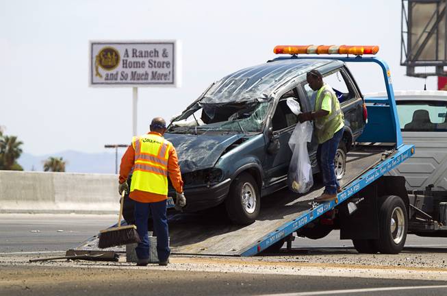 Tow truck drivers clean up after a fatal rollover on Highway 95 southbound at Jones Boulevard Monday, July 28, 2014. A 48-year-old man was ejected from the vehicle and died at the hospital.