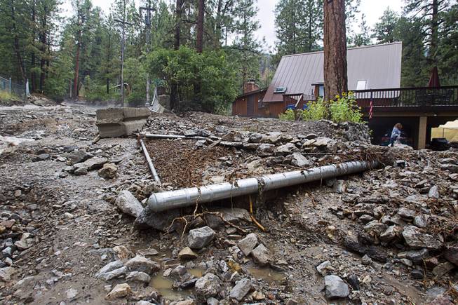 A downed fence is shown on Rainbow Canyon Boulevard in the Rainbow Subdivision on Mt. Charleston Monday, July 28, 2014. The neighborhood was hit hard by flooding and debris in runoff last year as well.