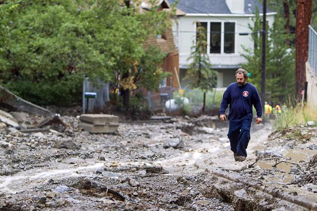 Volunteer firefighter Jim Tiscareno walks up Rainbow Canyon Boulevard in the Rainbow Subdivision on Mt. Charleston Monday, July 28, 2014. The neighborhood was hit hard by flooding and debris in runoff last year as well.