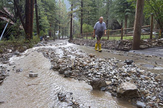 Resident Steve Kammer walks along Rainbow Canyon Boulevard in the Rainbow Subdivision on Mt. Charleston Monday, July 28, 2014. The neighborhood was hit hard by flooding and debris in runoff last year as well.