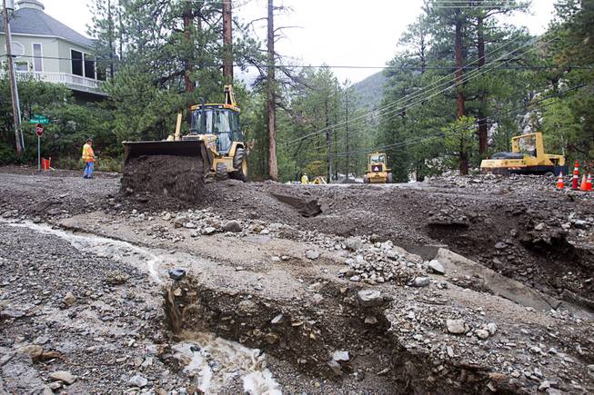 Work crews start repairs to Rainbow Canyon Boulevard in the Rainbow Subdivision on Mt. Charleston Monday, July 28, 2014. The neighborhood was hit hard by flooding and debris in runoff last year as well.