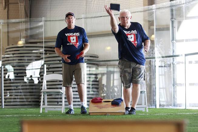 Tim Malte, left, and Keith Goodman compete during a cornhole tournament Saturday, July 26, 2014.