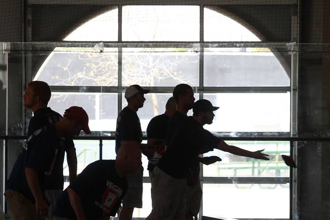 Players are seen in silhouette during a Cornhole tournament Saturday, July 26, 2014.