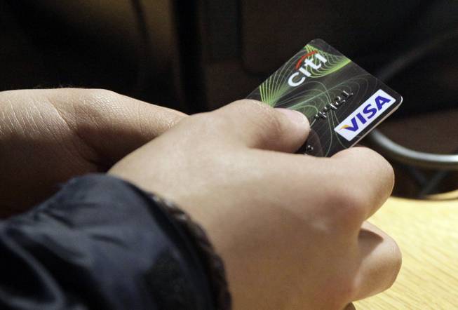 In this May 9, 2012, file photo, a Visa credit card is tendered at the opening of the Superdry store in New York's Times Square. 
