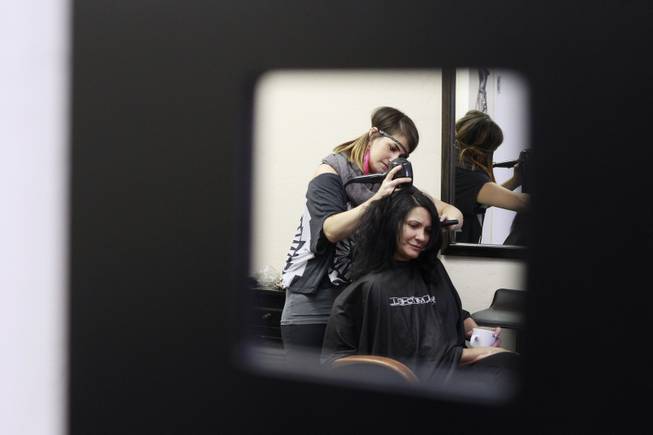 Cupcake Girls founder Joy Hoover works on the hair of Christine July 23, 2014.