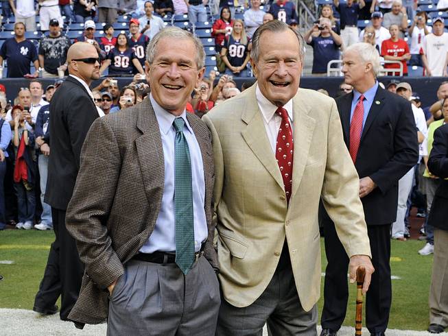This Oct. 25, 2009, file photo shows former Presidents George H. W. Bush, right, and George W. Bush before the Houston Texans NFL football game against the San Francisco 49ers in Houston. 