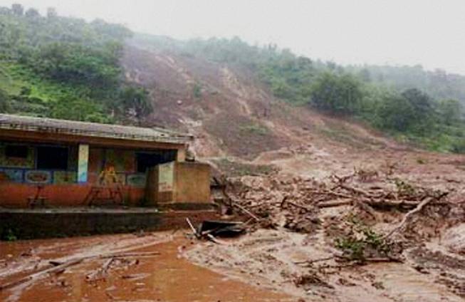Mud and slush surround a building after a mudslide in Malin village, in the western Indian state of Maharashtra, Wednesday, July 30, 2014.
