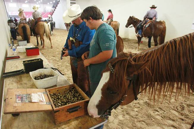 Frost Yourself sniffs around cartridges while Travis Lantis and his son Lucas Lantis reload during the Cowboy Mounted Shooting Association's Western U.S. ChampionshipThursday, July 31, 2014 at the South Point.