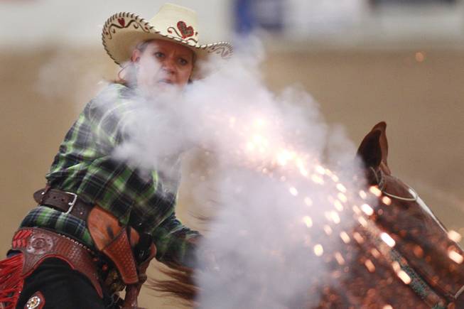 Denise Sullivan fires at a target during the Cowboy Mounted Shooting Association's Western U.S. ChampionshipThursday, July 31, 2014 at the South Point.