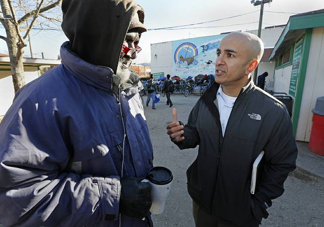 In this Dec. 4, 2013 file photo, Neel Kashkari, right, who later won the Republican nomination for governor of California, talks with Kenneth Whitaker, 62, at Loaves and Fishes homeless shelter in Sacramento, Calif. 