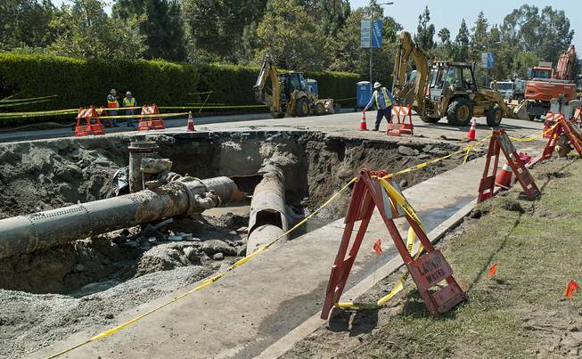 Los Angeles Department of Water and Power crews work to repair the "Y" shaped juncture where a water rupture occurred near the University of California, Los Angeles, involving two main trunk lines on Sunset Boulevard, Thursday, July 31, 2014. 