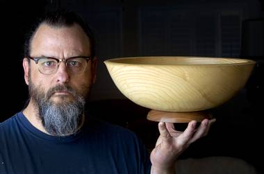 Robert Arnold of Dog House Workshop poses in his home workshop Thursday, July 31, 2014. Arnold is a craftsman who makes wooden bowls, ceramic pieces, mobiles and prints.