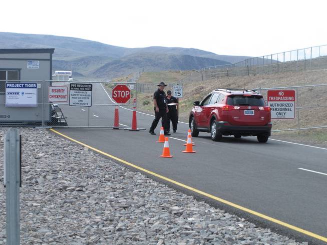 Security guards stop a car Friday Aug. 1, 2014, at the gate to the site Tahoe Reno Industrial Center about 15 miles east of Reno, where Tesla Motors has broken ground as one of the possible places to build a $5 billion "gigafactory'' to make lithium batteries for its electric cars.