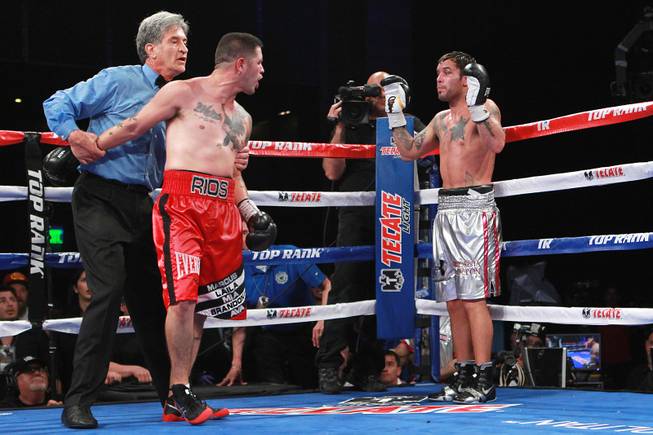 Referee Vic Drakulich holds back Brandon Rios as he goes after Diego Chaves after being separated because he was struck by a Chaves forearm to the mouth during the ninth round of their welterweight fight Saturday, Aug. 2, 2014 at the Cosmopolitan. Chaves was disqualified. 