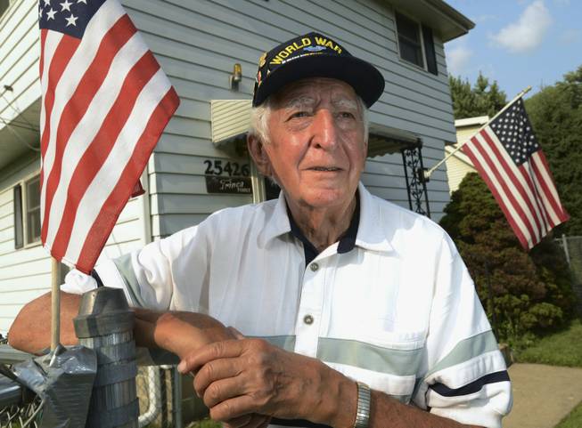 In this Thursday, July 31, 2014, photo, veteran John Trinca stands outside his home in Antioch Township, Ill. Trinca was with U.S. Army Pvt. Thomas Bateman, a soldier he had just met in the Philippines in 1945 in World War II, when Bateman was killed by Japanese machine gun fire. The Purple Heart that Bateman paid for with his life became lost and was eventually found in the 1950s by Tom McAvoy as a kid in Chicago. Trinca will be on hand Sunday, Aug. 3, 2014, when the Purple Heart will be returned to Bateman’s family in Grayslake, Ill.