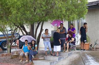 Neighbors watch as Metro Police investigate an officer-involved-shooting near Pecos and Alexander roads August 3 , 2014.