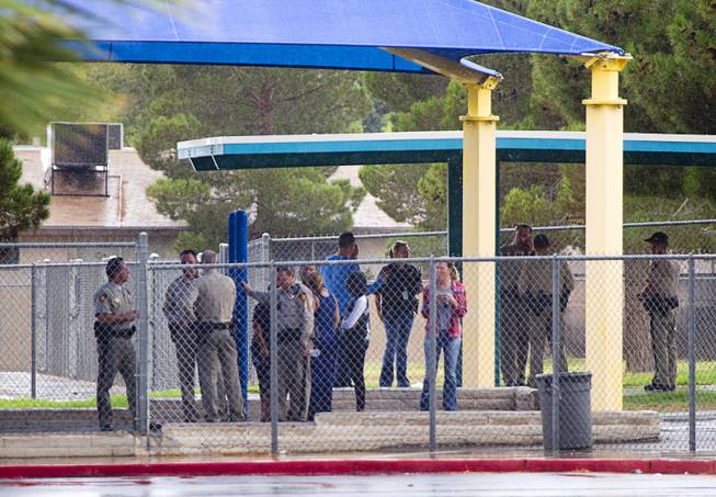 Metro Police officers take advantage of a covered playground at Cox Elementary School by the scene of an officer-involved-shooting near Pecos and Alexander roads August 3 , 2014.