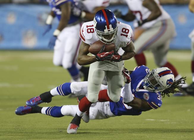 New York Giants wide receiver Marcus Harris (18) tries to break away from Buffalo Bills defensive back Mario Butler (30) after Harris caught a pass in the second quarter at the Pro Football Hall of Fame exhibition NFL football game Sunday, Aug. 3, 2014, in Canton, Ohio.
