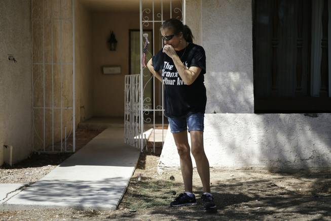 Julie Ramos cries while standing in front of her home Wednesday, July 30, 2014, in Las Vegas. Ramos was injured and her husband Richard Ramos was killed in a home invasion Tuesday.