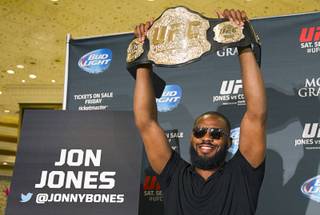 UFC light heavyweight champion Jon Jones holds up his belt during a UFC press conference at the MGM Grand Monday Aug. 4, 2014.