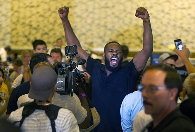 UFC light heavyweight champion Jon Jones is triumphant as he leaves the MGM lobby after getting into a fight with challenger Daniel Cormier during a UFC press conference at the MGM Grand Monday Aug. 4, 2014.