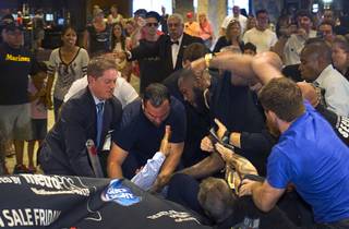 MGM Grand security try to to separate UFC light heavyweight champion Jon Jones (top) and challenger Daniel Cormier after the two started fighting during a UFC press conference at the MGM Grand Monday Aug. 4, 2014. 