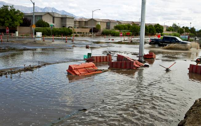 A truck is driven quickly through deep water collecting due to recent heavy rains along West Grand Teton Drive at the intersection of North Tenaya Way on Monday, August 4, 2014.